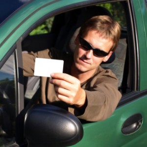 Man showing driver's license while sitting in car